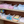 Load image into Gallery viewer, Shelves with folded towels in various colors
