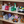 Load image into Gallery viewer, Shelf with various stuffed animals and small books on a wooden shelf.
