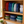 Load image into Gallery viewer, Stacked plastic food containers with lids on a wooden shelf.
